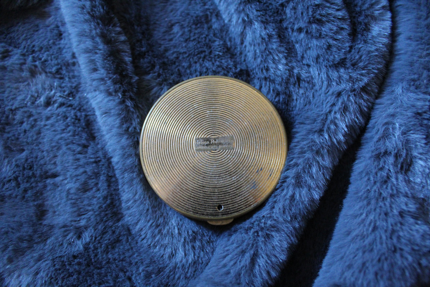 Round gold colour compact with clear jewel detail