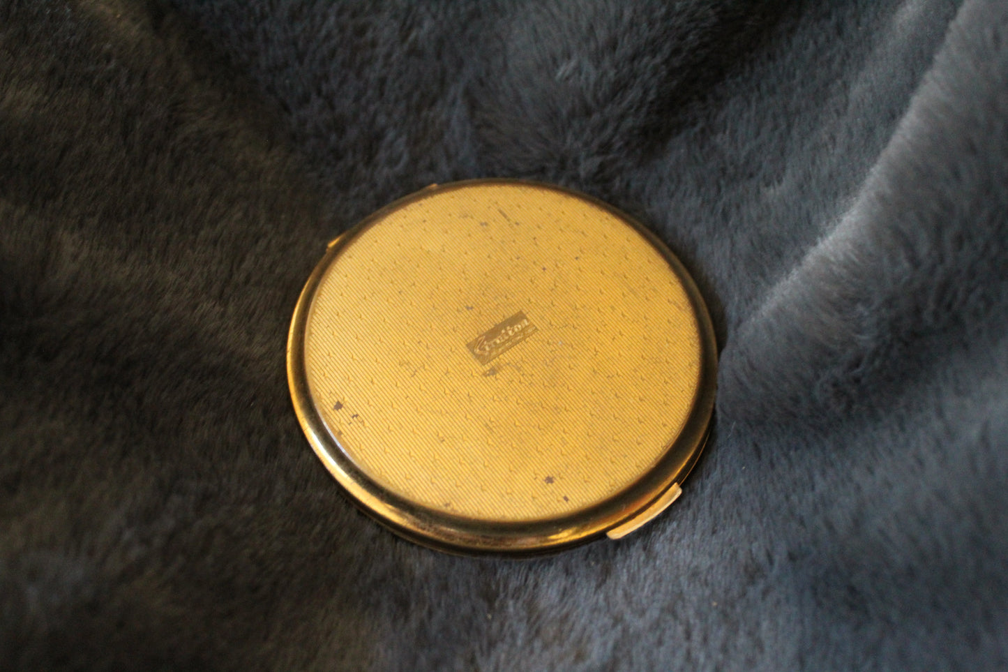 Round, gold Stratton compact