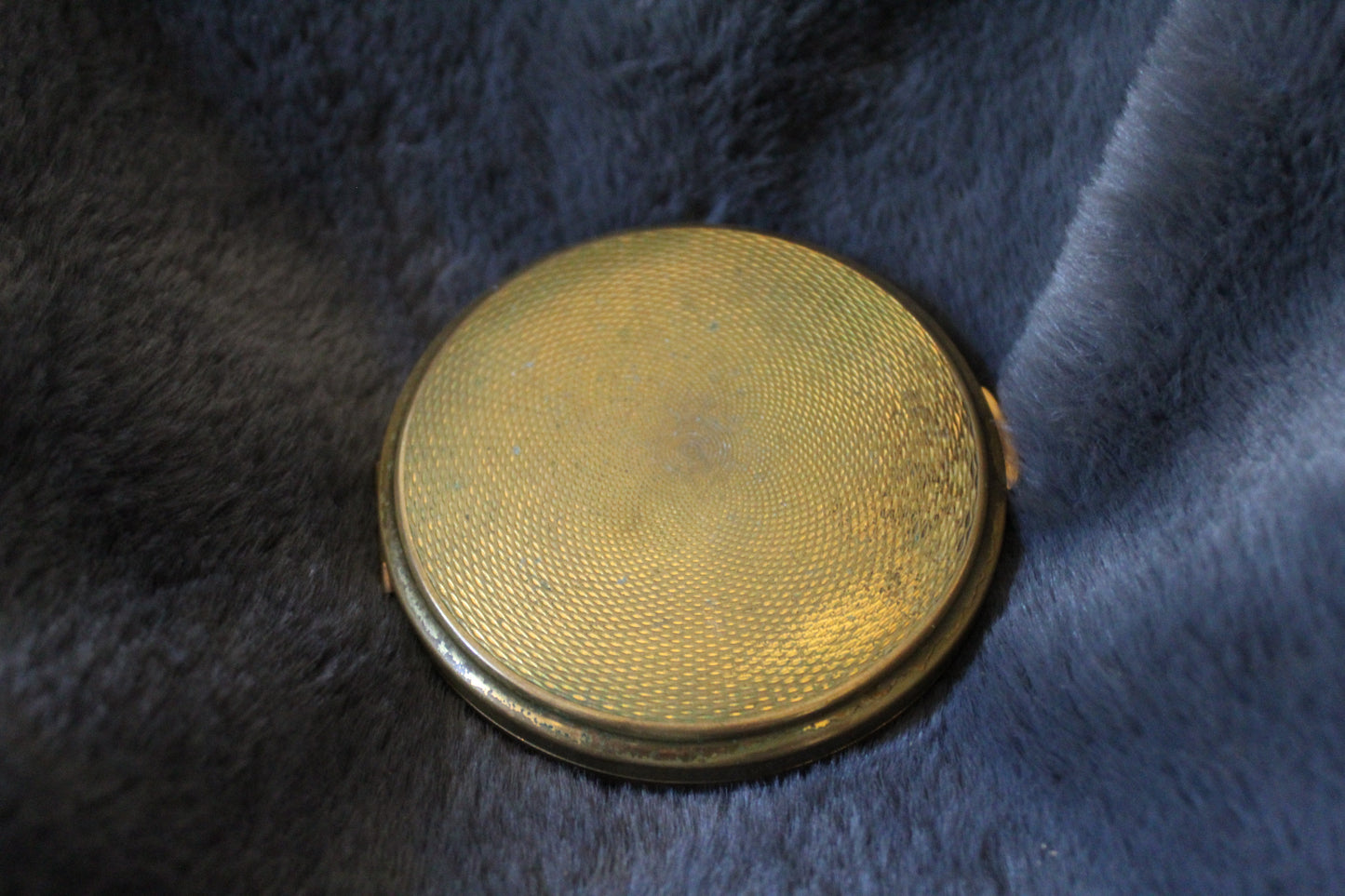 Round gold compact with floral details