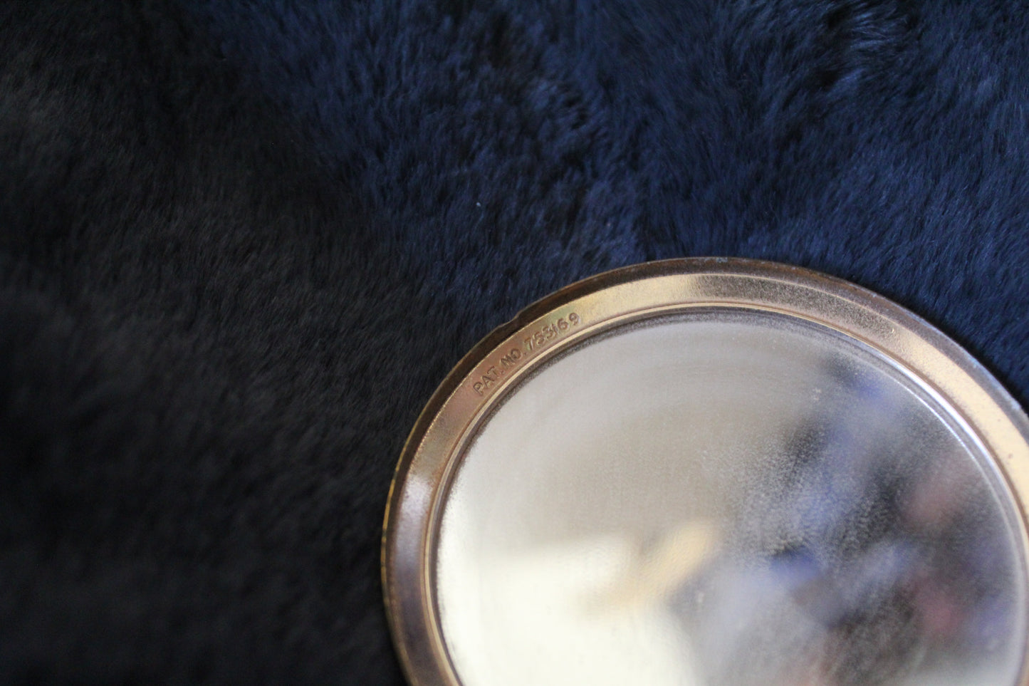 Round gold compact with floral details